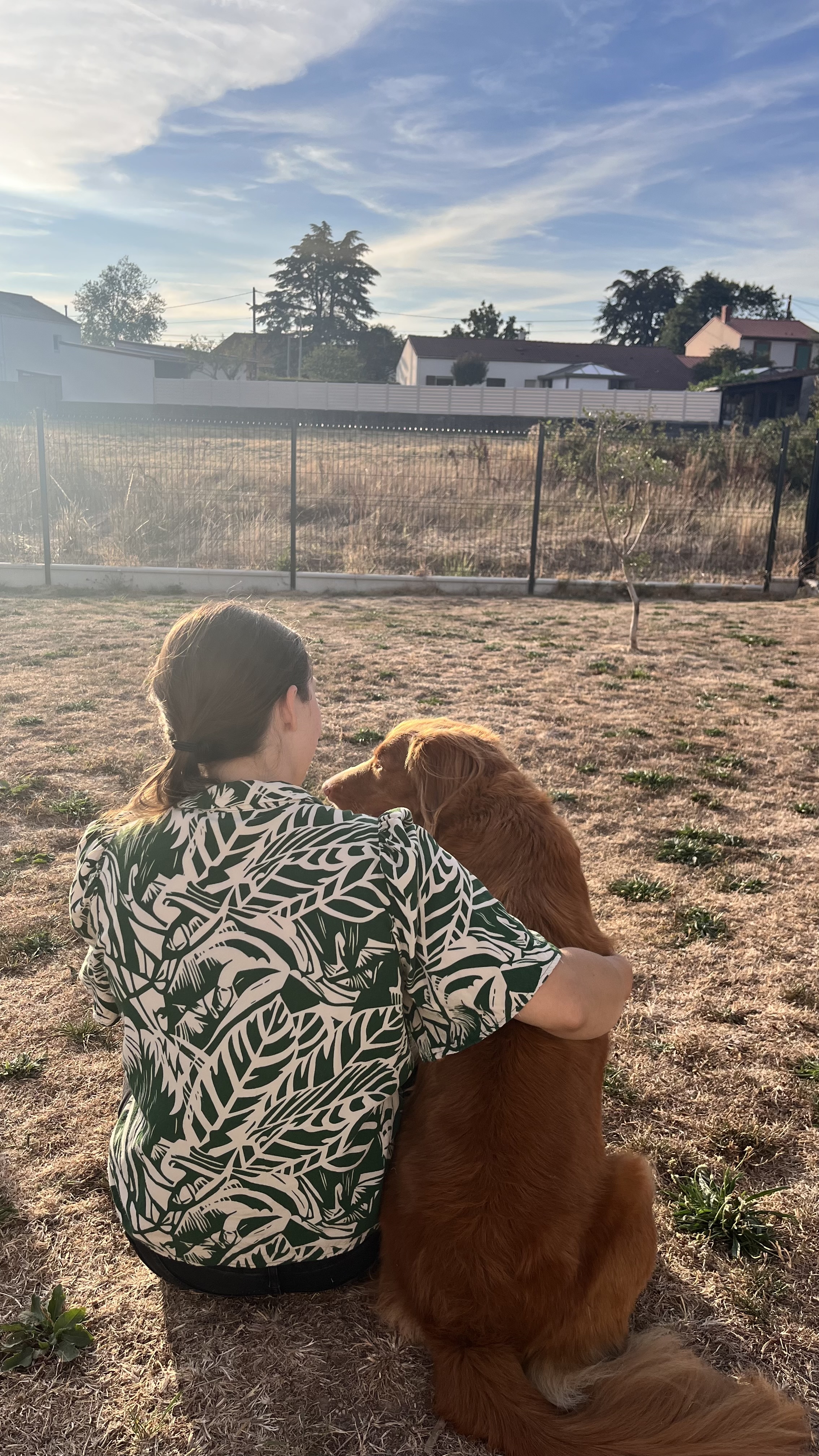 Alexia partage un moment avec son chien dans le jardin